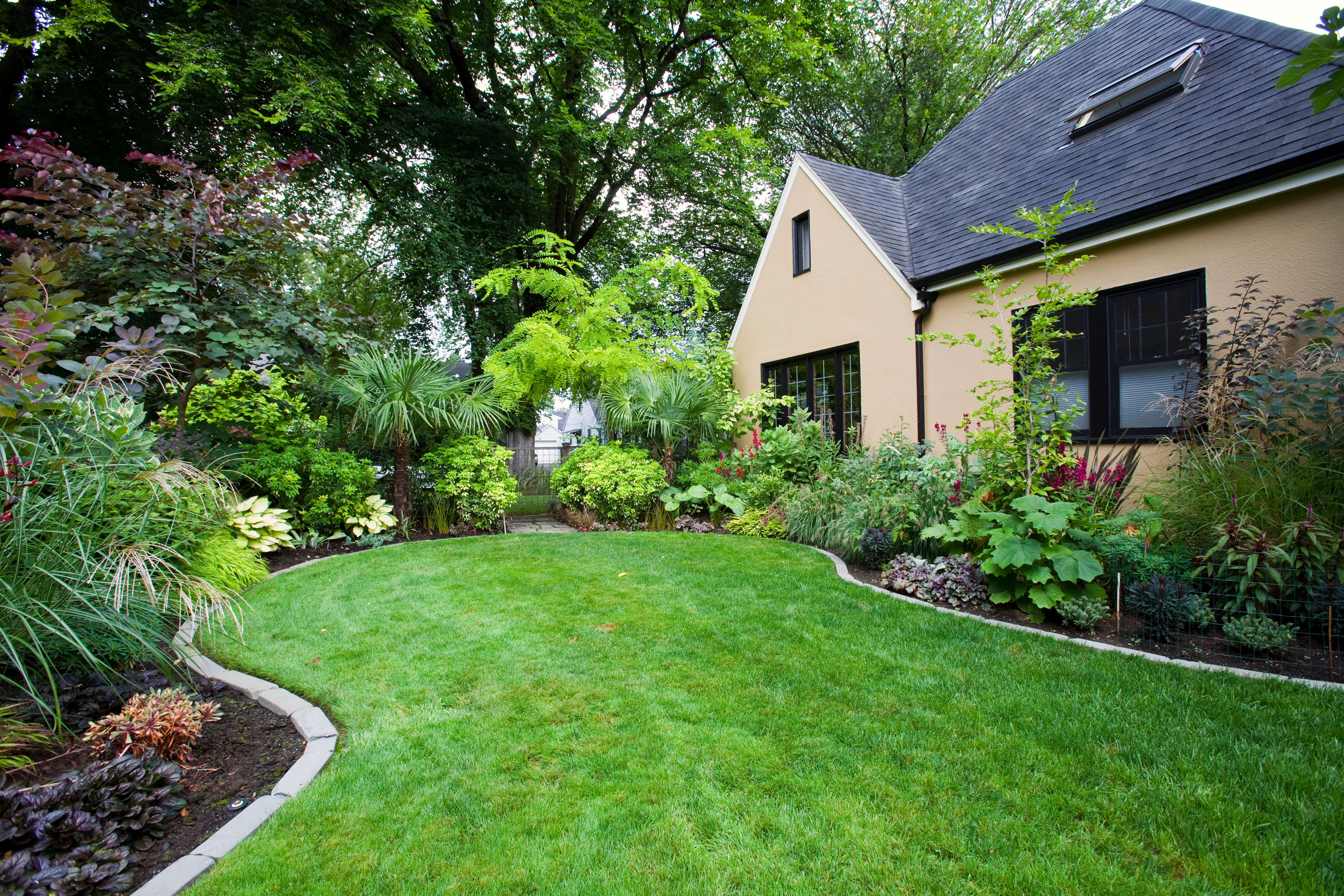 Finished lawn and garden beds beside a house